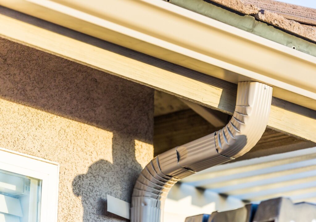 A home exterior featuring newly installed seamless curved aluminum rain gutters 