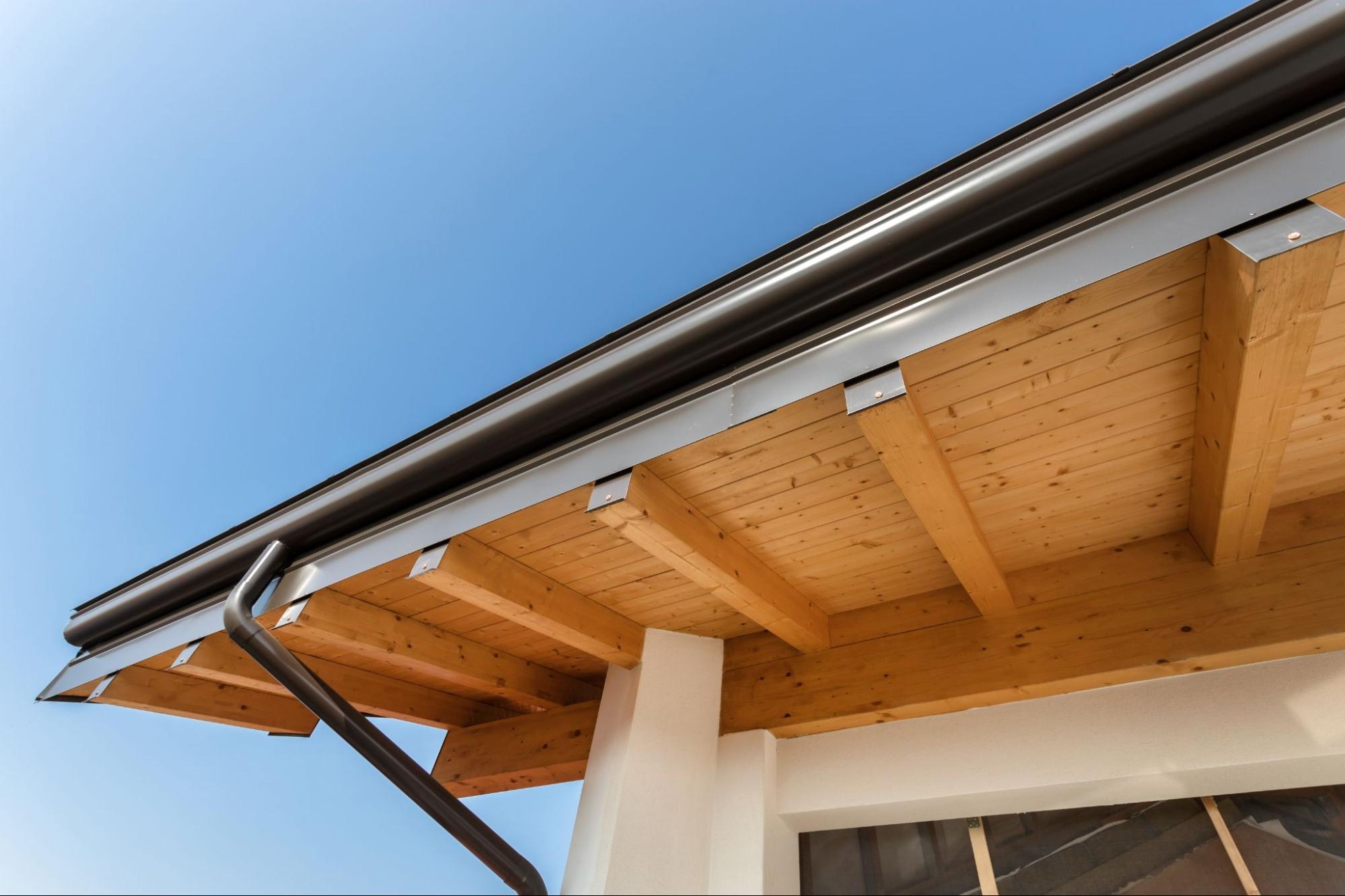 Energy-efficient wooden home with durable steel roof gutters