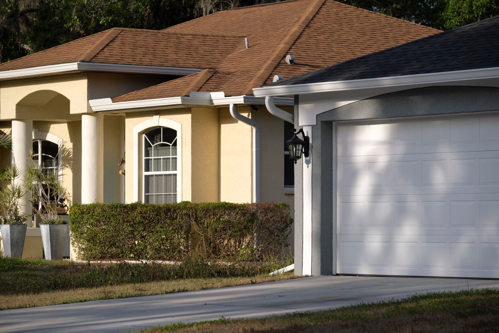 Modern American home featuring a wide double garage door replacement and concrete driveway.